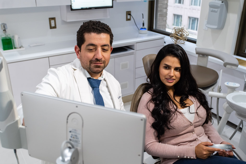 Dr. Husam Almunajed reviewing digital smile design with a patient at Empire Dental Aesthetics in Midtown Manhattan