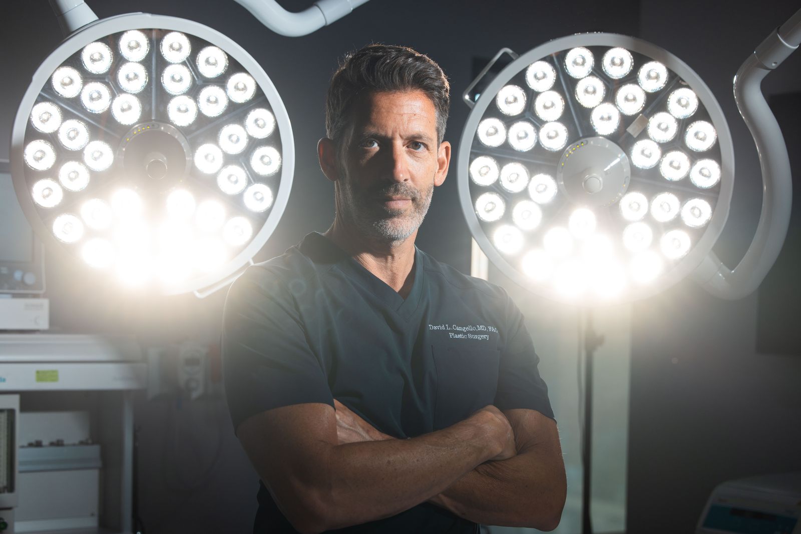 Dr. David Cangello standing between surgical lights in his private Manhattan operating room