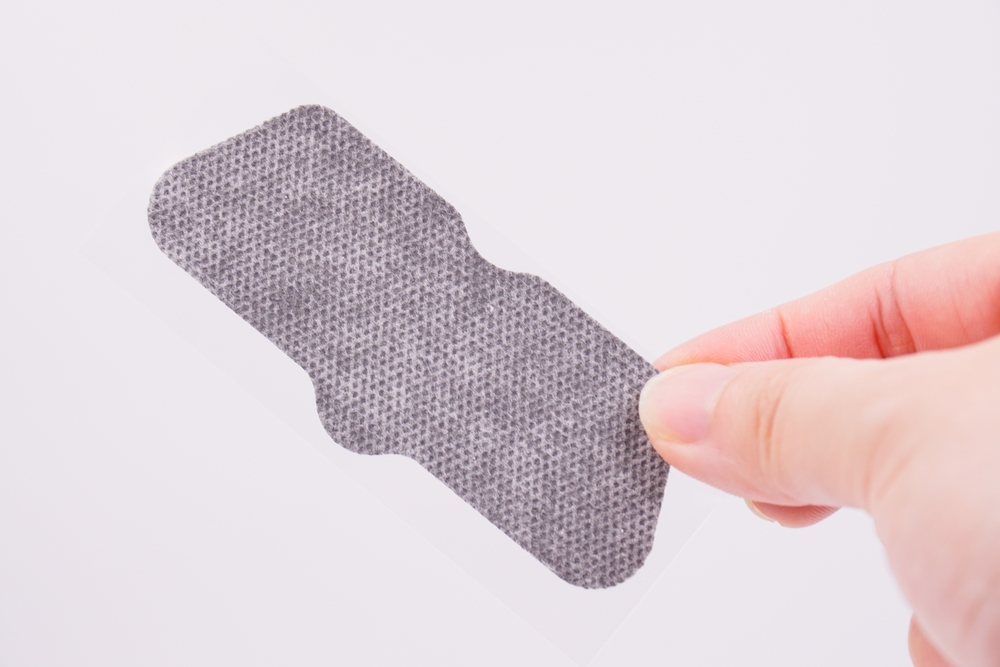 Close-up of a handheld pore vacuum device being used on facial skin to extract blackheads